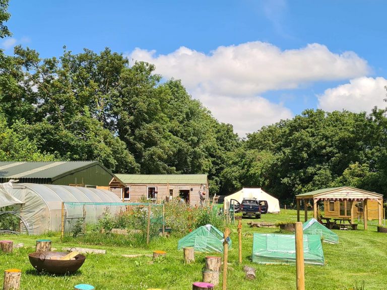 View of woodstock community with wooden buildings on a field.