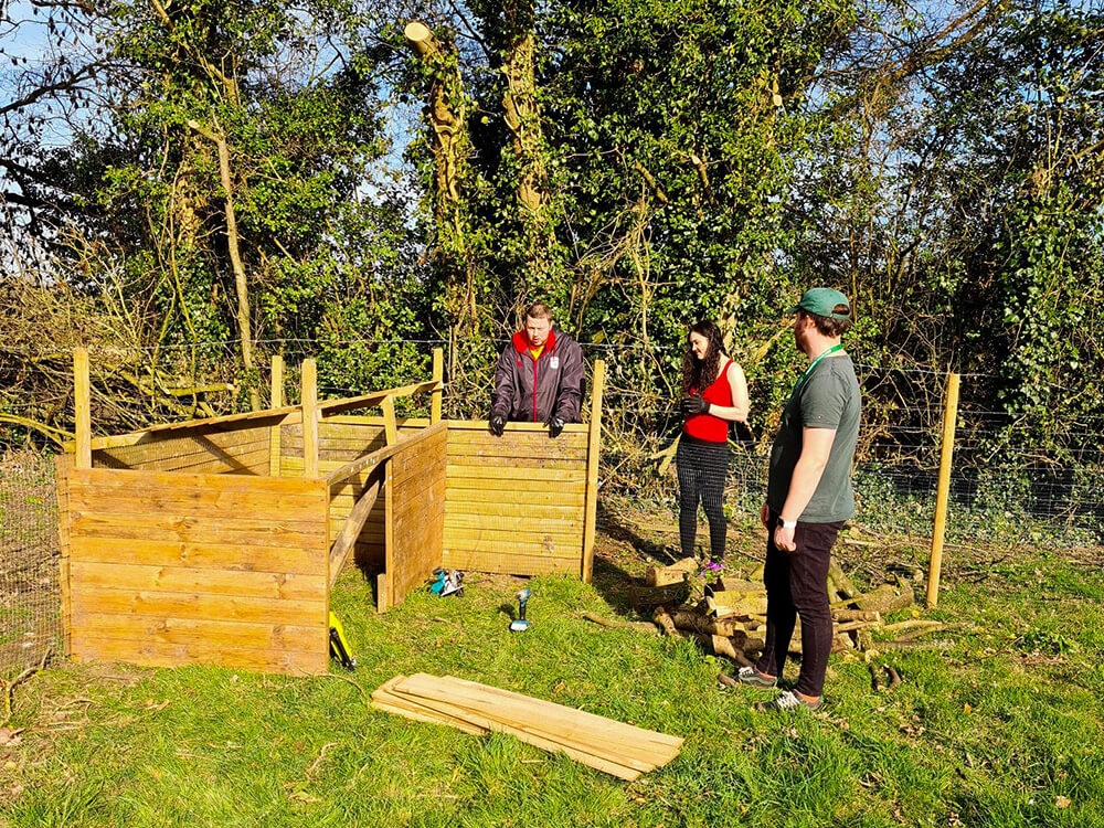 Adults learning how to build a fence.